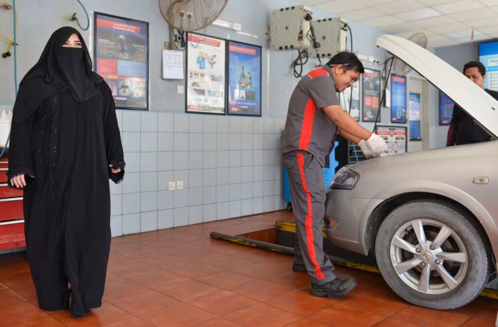 Saudi gas station supervisor Mervat Bukhari standing near a worker at her workplace in Khobar.