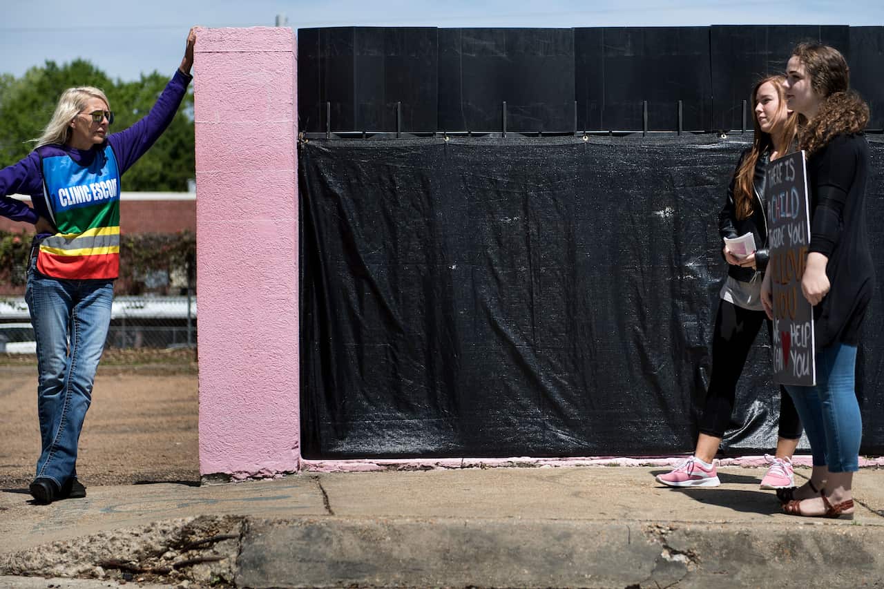 A volunteer who escorts patients into the last abortion clinic in Mississippi and pro-life activists wait for patients to arrive on 5 April 2018.