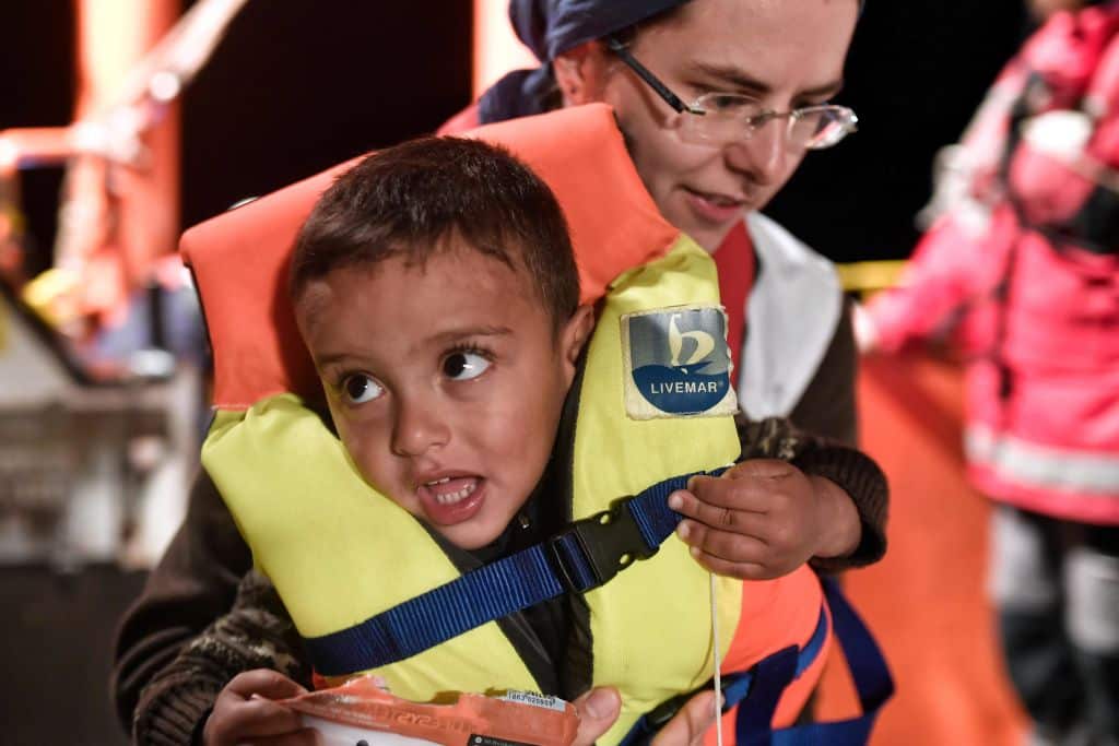 A rescuer helps a child aboard the Aquarius ship.