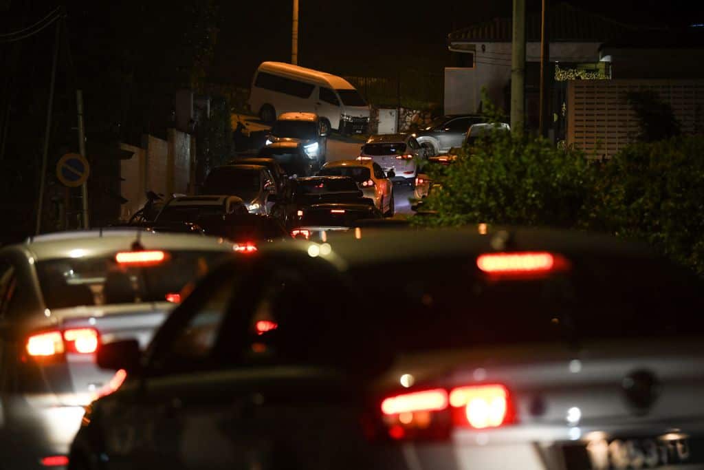 Malaysian police cars enter the road leading to former Prime Minister Najib Razak's residence in Kuala Lumpur on May 16, 2018.