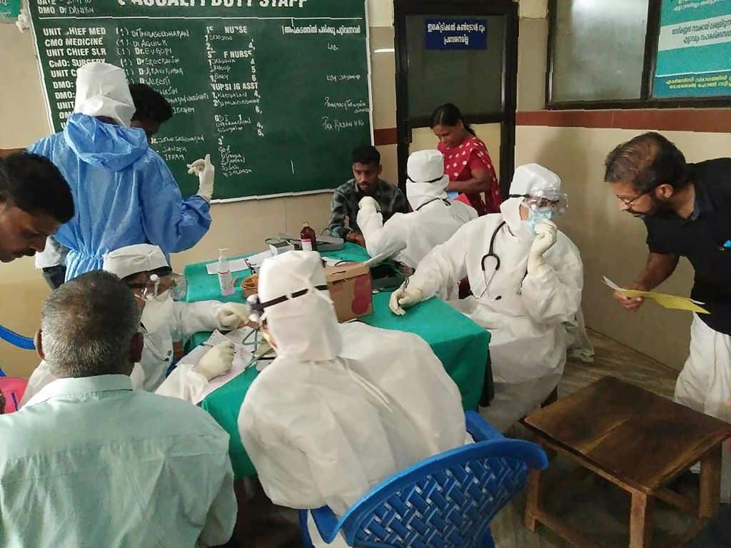 Medical personnel wearing protective suits check patients at the Medical College hospital in Kozhikode.