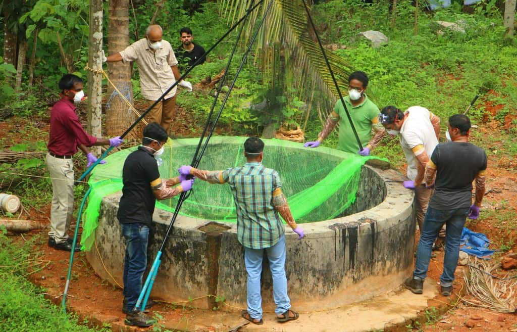 Officials inspect a well in the Kozhikode district.