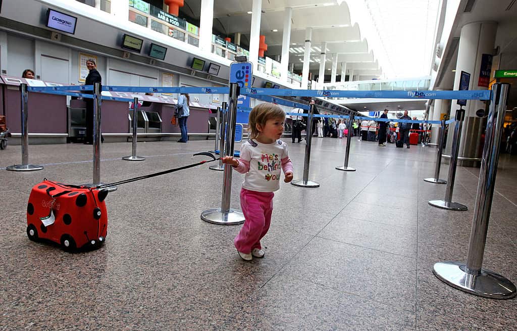 A small girl pulls her bag through an aiport