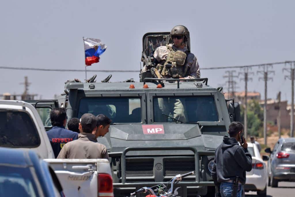 Russians forces are seen as displaced Syrians from the Daraa province come back to their hometown in Bosra, southwestern Syria, on July 11, 2018.