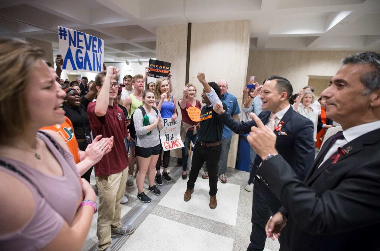 Florida Rep. Robert Asencio, right, and Rep. Carlos Guillermo Smith, second from right, lead students as they chant protest slogans