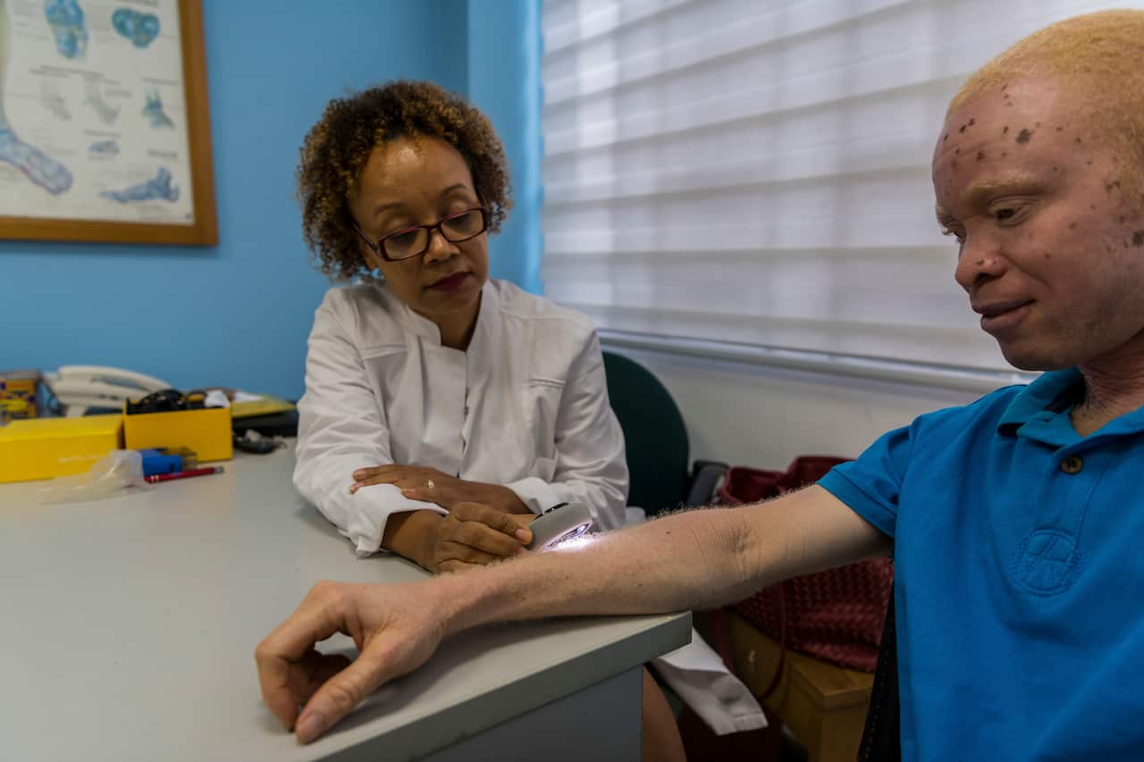 Kwame Andrews Daklo, an albinism advocate, receives a skin screening from Dr. Jeannette Aryee-Boi, a dermatologist who volunteers with the albinism community in Accra, Ghana.