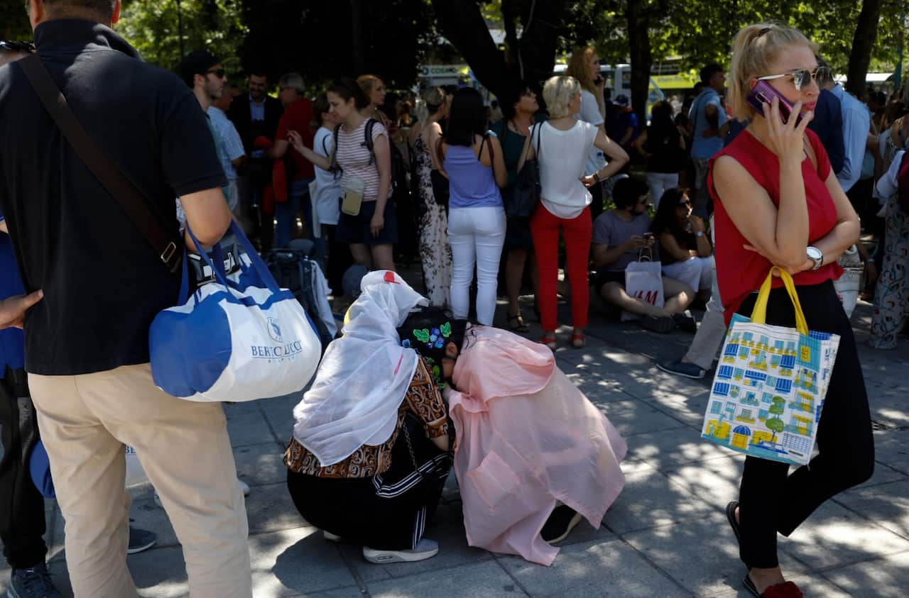 Tourist hug each other in Syntagma square after a strong earthquake hit near the Greek capital of Athens, Friday, July 19, 2019.