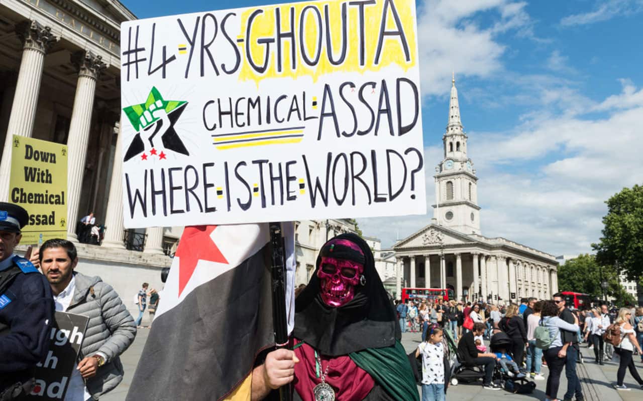 A group of protesters stage a demonstration in Trafalgar Square in London on the 4th anniversary of the Ghouta chemical attacks.