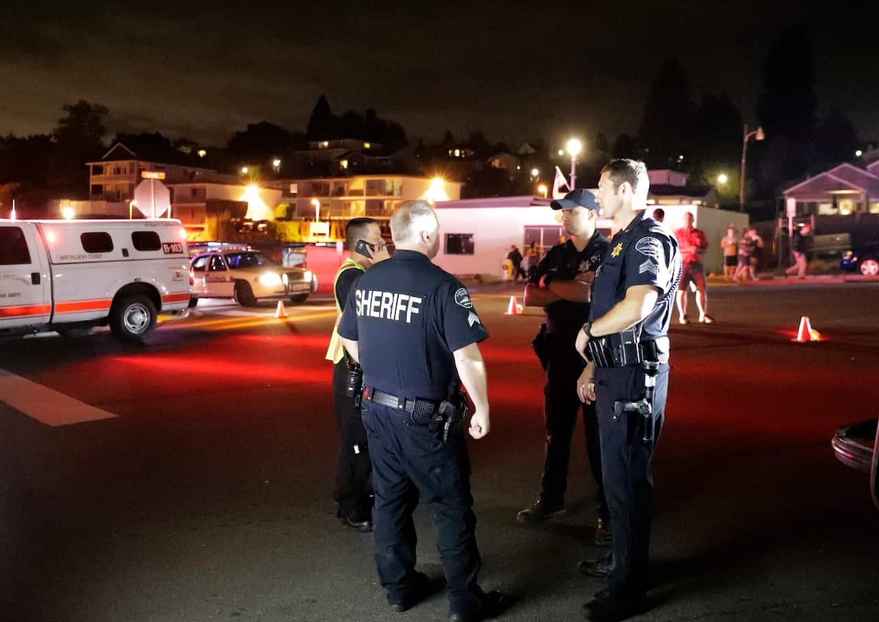 Law enforcement officials stand at a staging area, Friday, Aug. 10, 2018, at the ferry terminal in Steilacoom