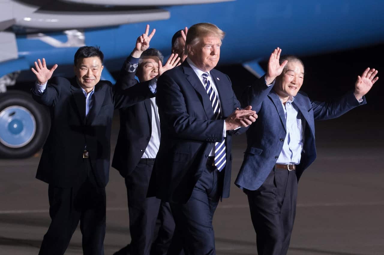 US President Donald J. Trump (C) walks with three US detainees that were released by North Korea; Tony Kim (L), Kim Hak-Song (back, C) and Kim Dong-Chul (R)