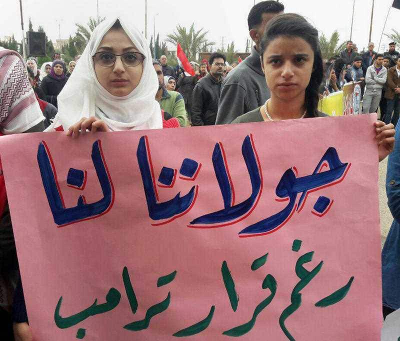 Syrians hold an Arabic banner 