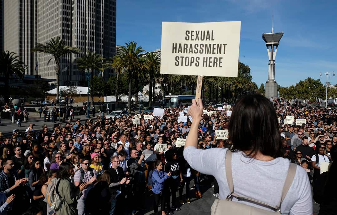 Google employees in San Francisco carrying signs with messages such as "Don't be evil" and "Sexual harassment stops here". 