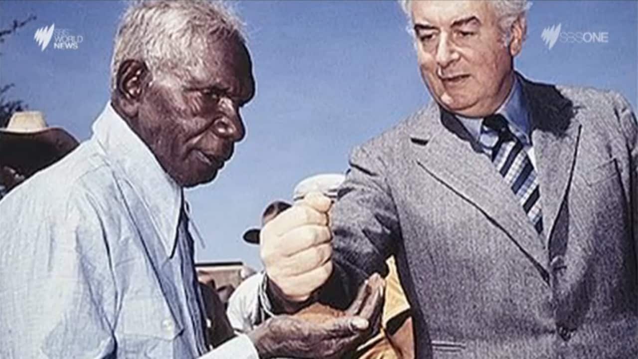 Gough Whitlam pouring soil into the hands of elder Vince Lingiari.