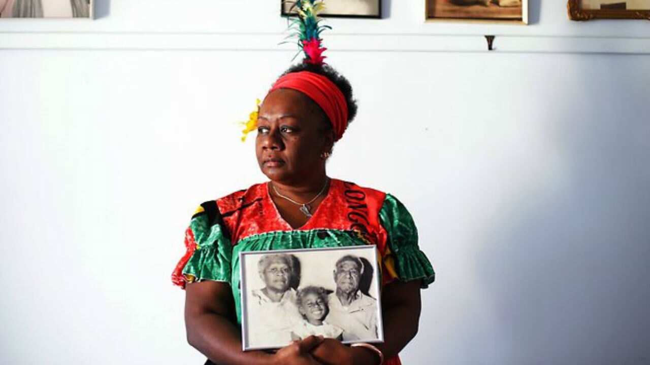 Emelda Davis holding a photograph of her grandparents.