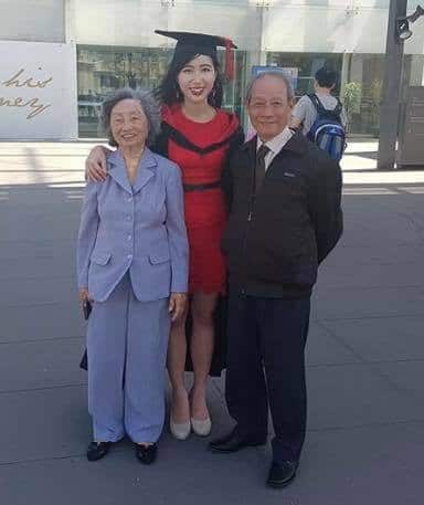 Lily with her grandparents at her graduation.