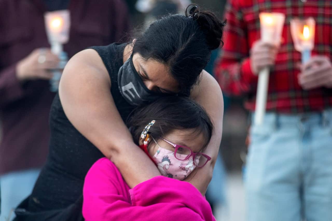 A mother hugs her daughter during a vigil in Toronto for the Indigenous children whose remains were uncovered near Kamloops.