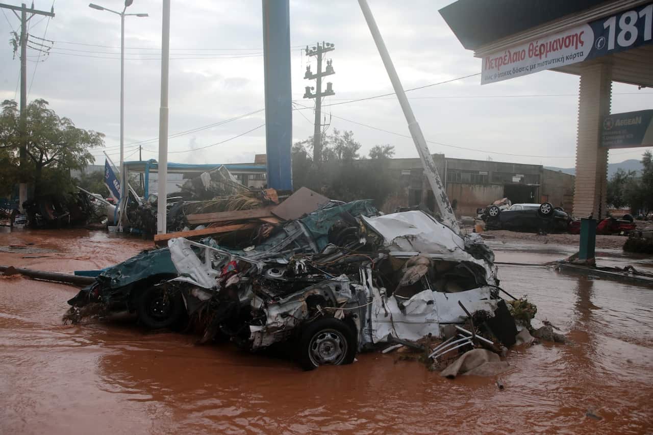 Destroyed cars in a mud covered flooded road in the centre of Mandra, western Attica, Greece, 15 November 2017 (AAP)