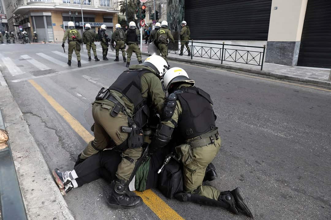 Riot policemen detain a protester during a scuffle on the sidelines of the rally in Athens.