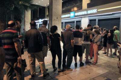 People queue up to withdraw money from an ATM outside a branch of Greece's National Bank in Athens, Greece, 28 June 2015. (EPA/SIMELA PANTZARTZI)
