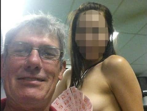 Ross Macdonald posing with a topless woman in Thailand. 