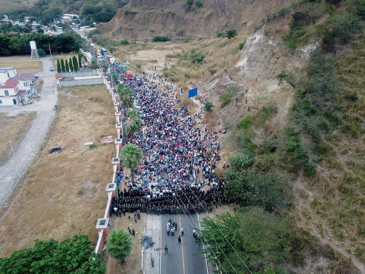 Guatemalan soldiers and policemen form a human barricade to stop Honduran asylum seekers walking on a highway near to Chiquimula, Guatemala.