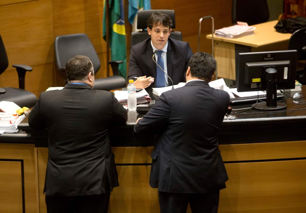 Brazilian judge Daniel Werneck Cotta talks with lawyers before the start of a pre-trial hearing of Mario Marcelo Ferreira dos Santos Santoro