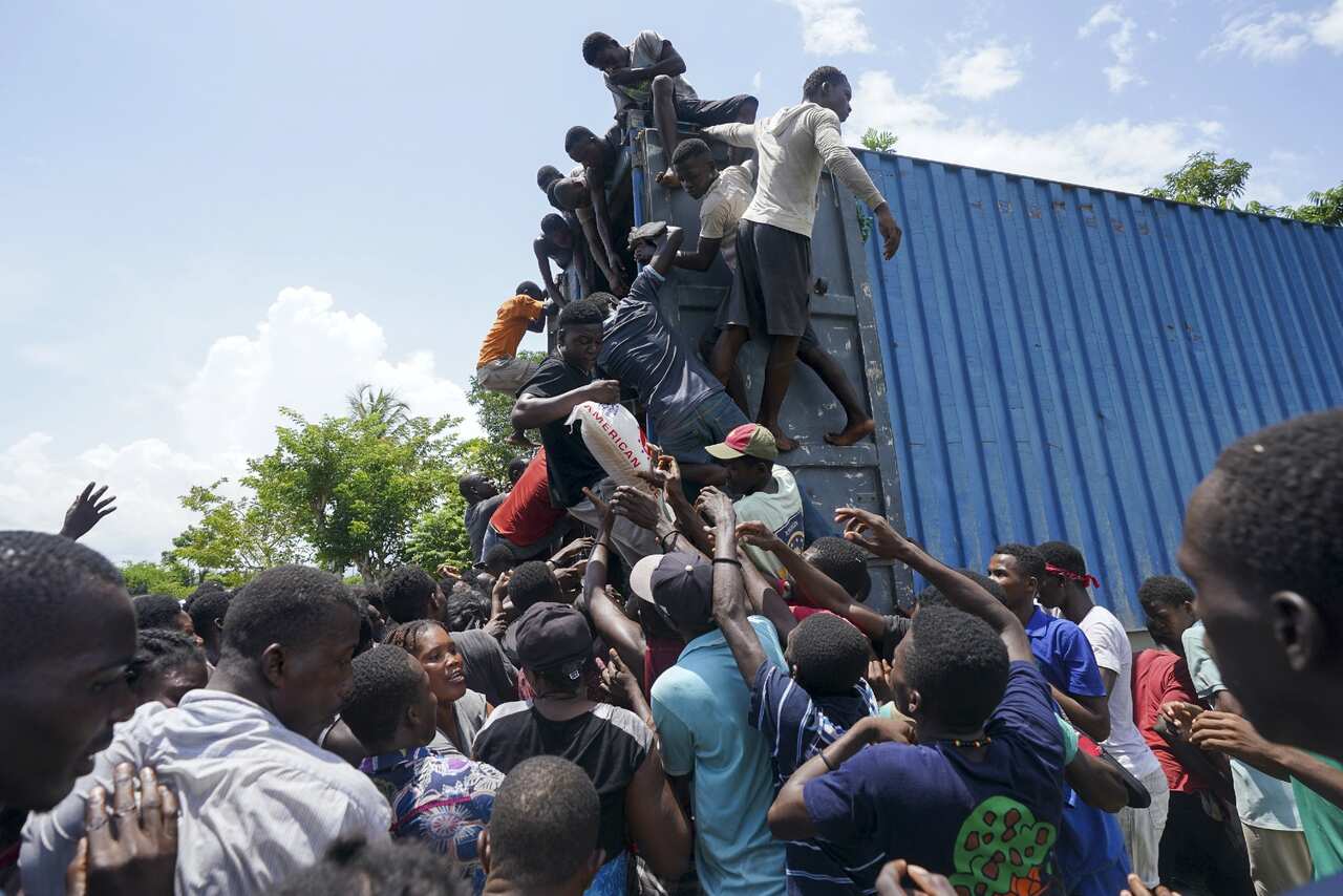 Residents overtake a truck loaded with relief supplies in Vye Terre, Haiti.