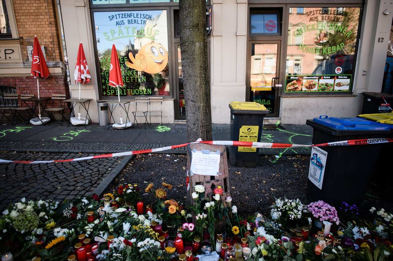 Flowers and candles are placed in front of the Kebab snack shop that was also targeted in the attack. 
