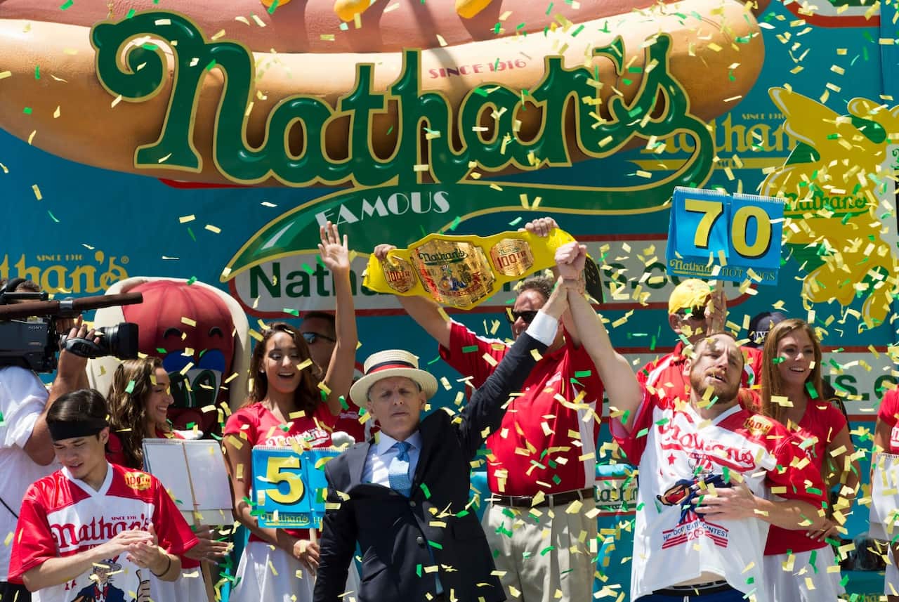 Joey Chestnut, right, is declared Nathan's Famous Fourth of July International Hot Dog Eating Contest winner, ahead of Stonie (left)