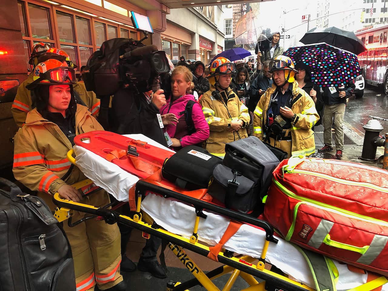 Firefighters prepare to bring a stretcher into a building.