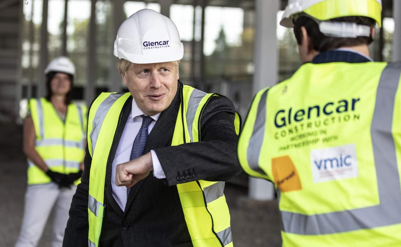 Prime Minister Boris Johnson bumps elbows with scientists as he visits the construction site of the new vaccines Manufacturing and Innovation Centre