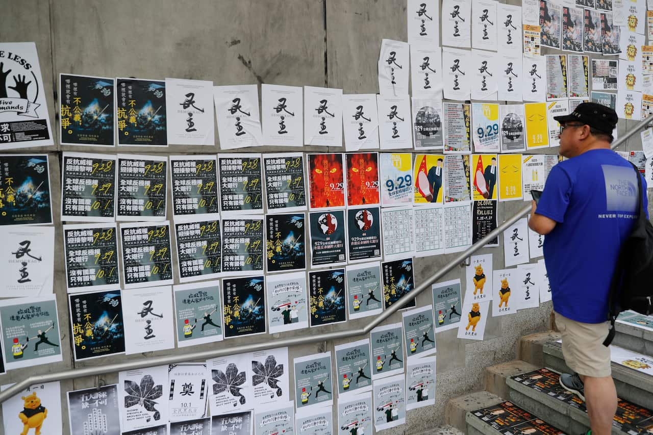 A man looks at the  newly created Lennon Wall, made with a mosaic of post-its, posters and notes outside the Central Government Complex.