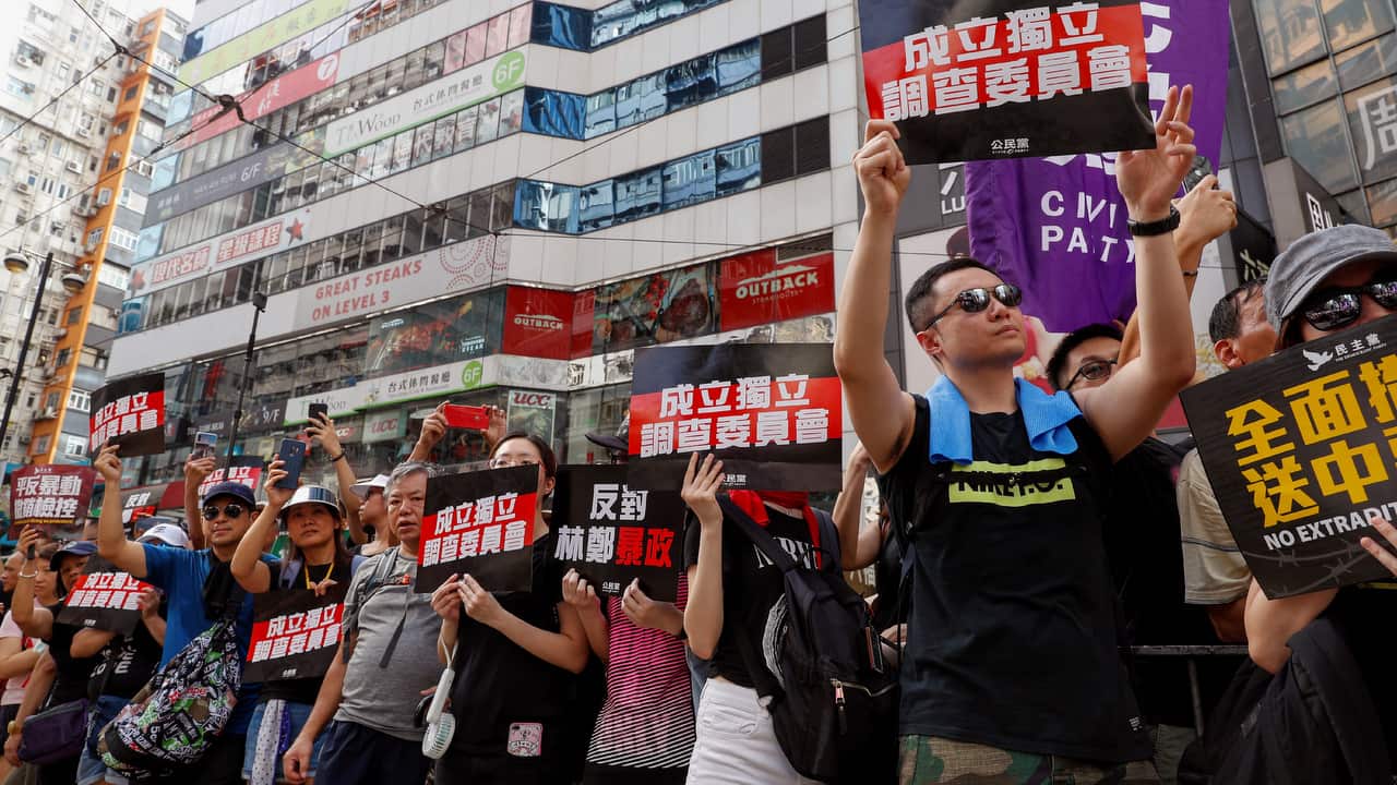 Protesters hold placards reads "Form an independent investigation on legislative" as they take part in a march in Hong Kong.