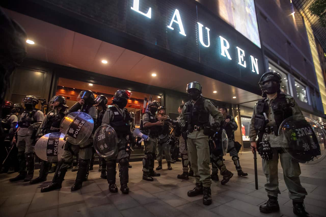 Police in riot gear stand on the street, ahead of the fresh round of protests. 