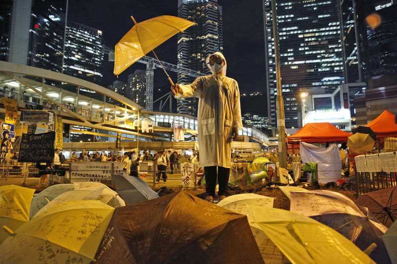 In a 2014 photo a protester holds an umbrella during a performance on a main road in the occupied areas outside government HQ in Hong Kong's Admiralty.