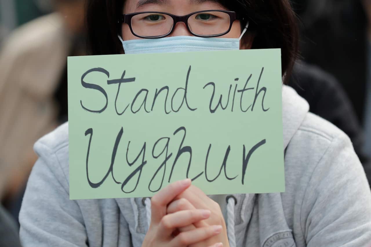 A man holds a sign during the rally to show support for Uighurs. A large number of the Muslim minority are being held in re-education camps in China.