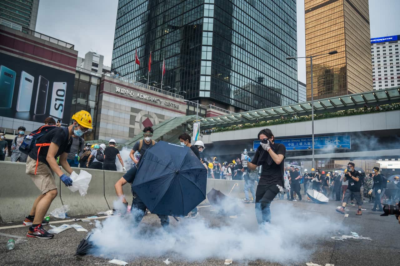 Protester trying to use water to put out the tear gas which the police used against them.