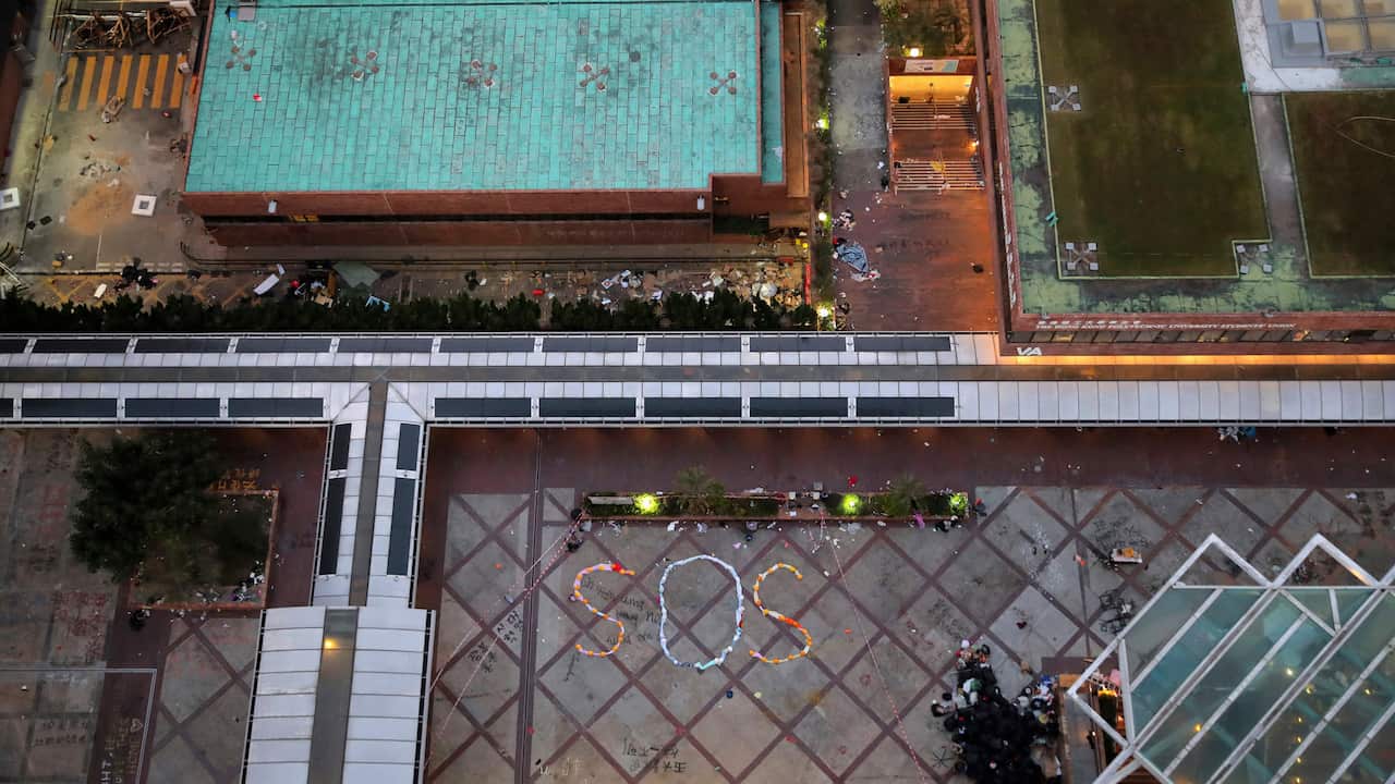 An aerial view of a "SOS" sign formed with clothes and helmets inside the Hong Kong Polytechnic University campus.