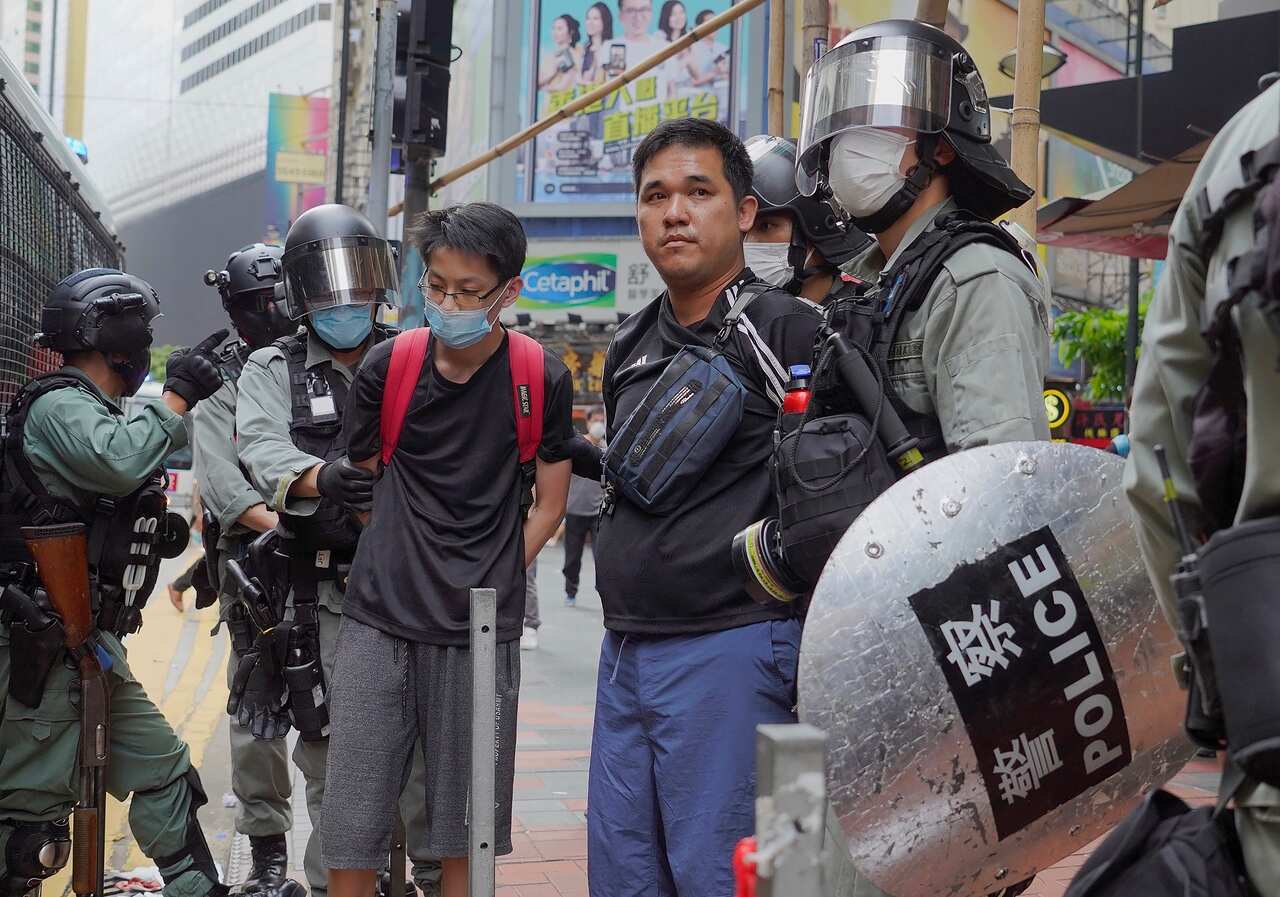 Riot police arrest protesters during a rally against a proposed security law.