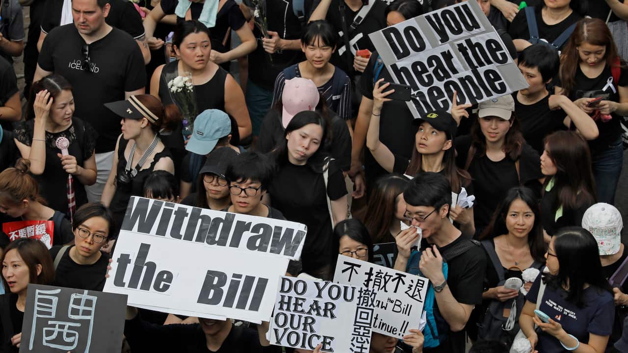 Protesters raise placards as they march on the streets against an extradition bill in Hong Kong.