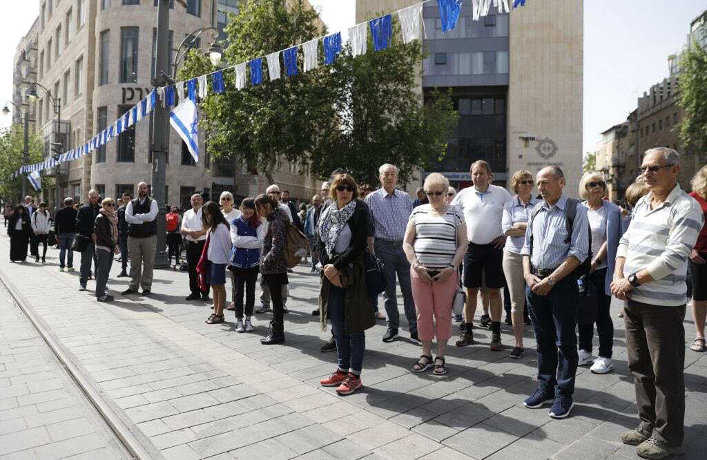 People stop and stand in silence on a Jerusalem's downtown street on April 12, 2018, as sirens wailed across Israel