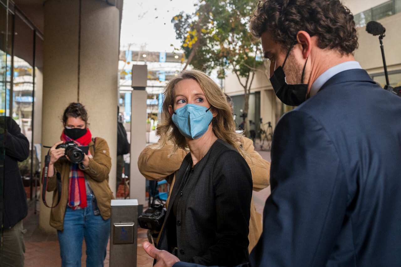 Elizabeth Holmes looks at her partner, Billy Evans, as they walk into federal court in San Jose, California.