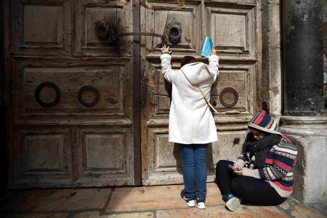 Christian pilgrims pray outside the Church of the Holy Sepulcher closed in Israel protest.