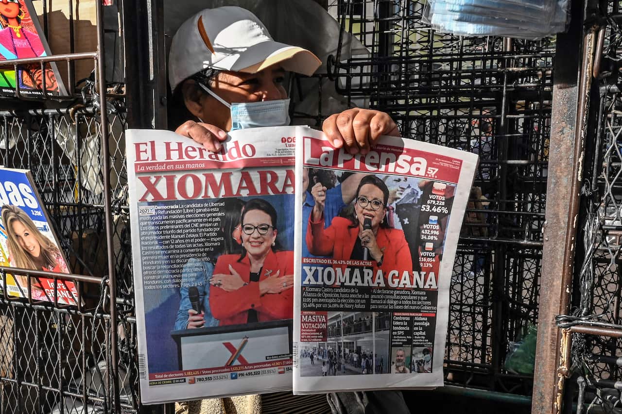 A vendor shows the covers of newspapers depicting left-wing opposition candidate Xiomara Castro, in Tegucigalpa on November 29, 2021.