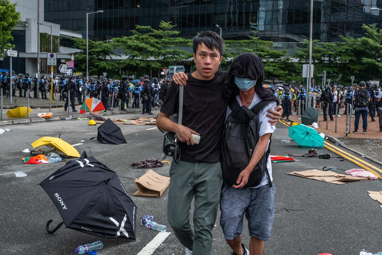 Roy Kwong, a politician, escorts a protester to an ambulance during early-morning clashes with the police in the Wan Chai district of Hong Kong, July 1, 2019. Kwong has emerged as a hero for the city’s youth and a leading voice for moderation during the p