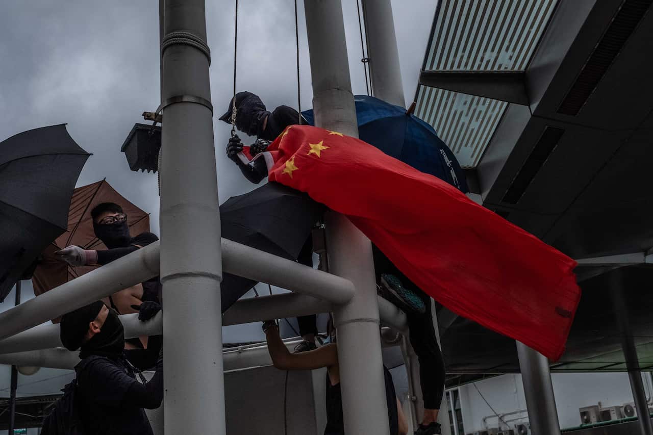 Protestors take down a national Chinese flag in Hong Kong.