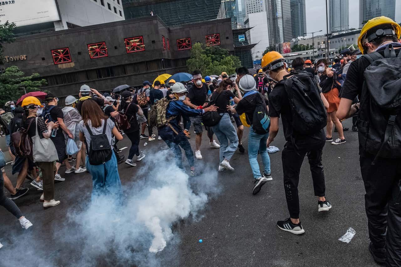 Protesters flee from a tear gas canister outside the Legislative Council in Hong Kong. 