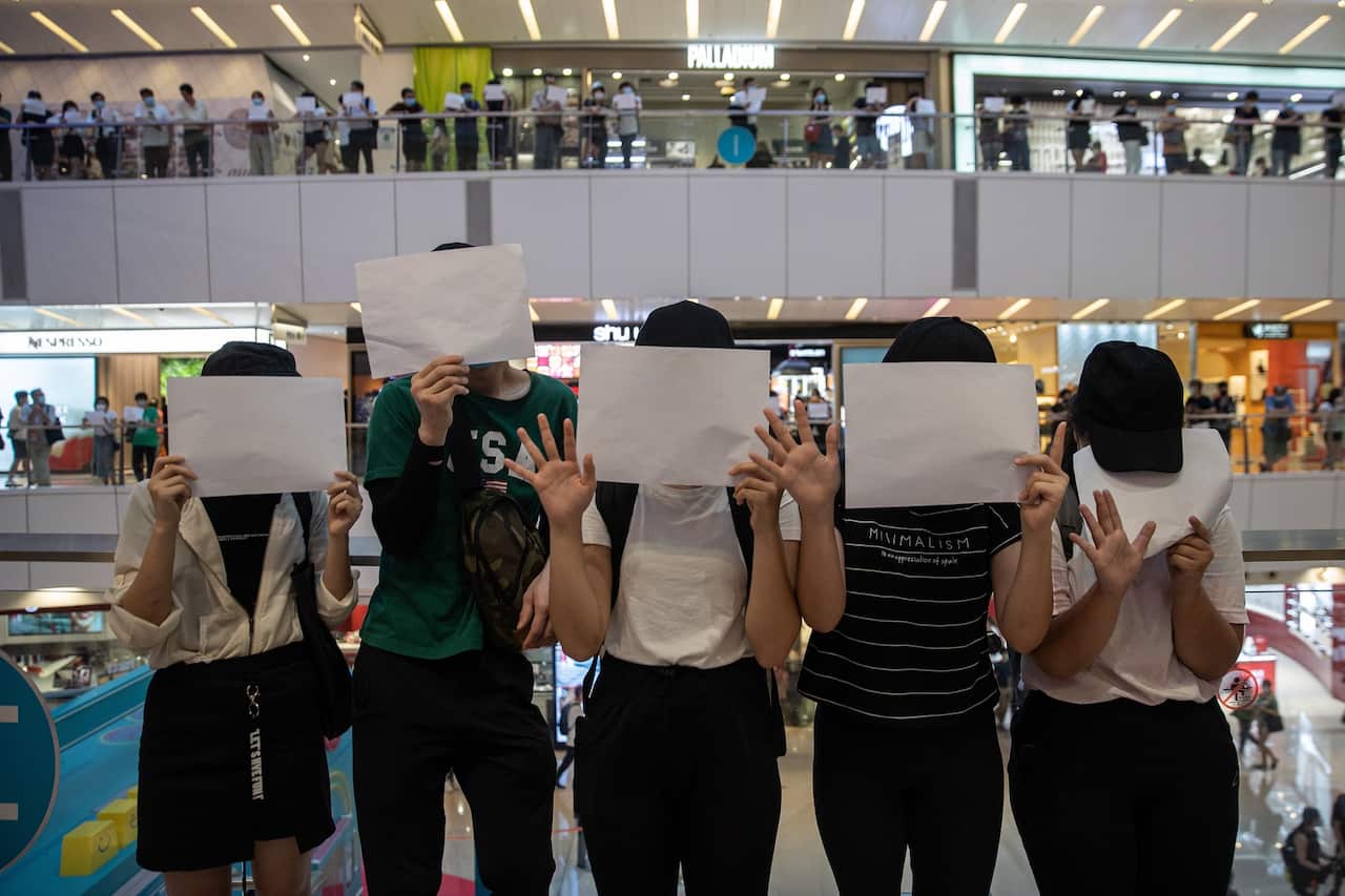 Protesters display sheets of plain white paper during a protest in a shopping mall in Hong Kong, China, 6 July 2020.  