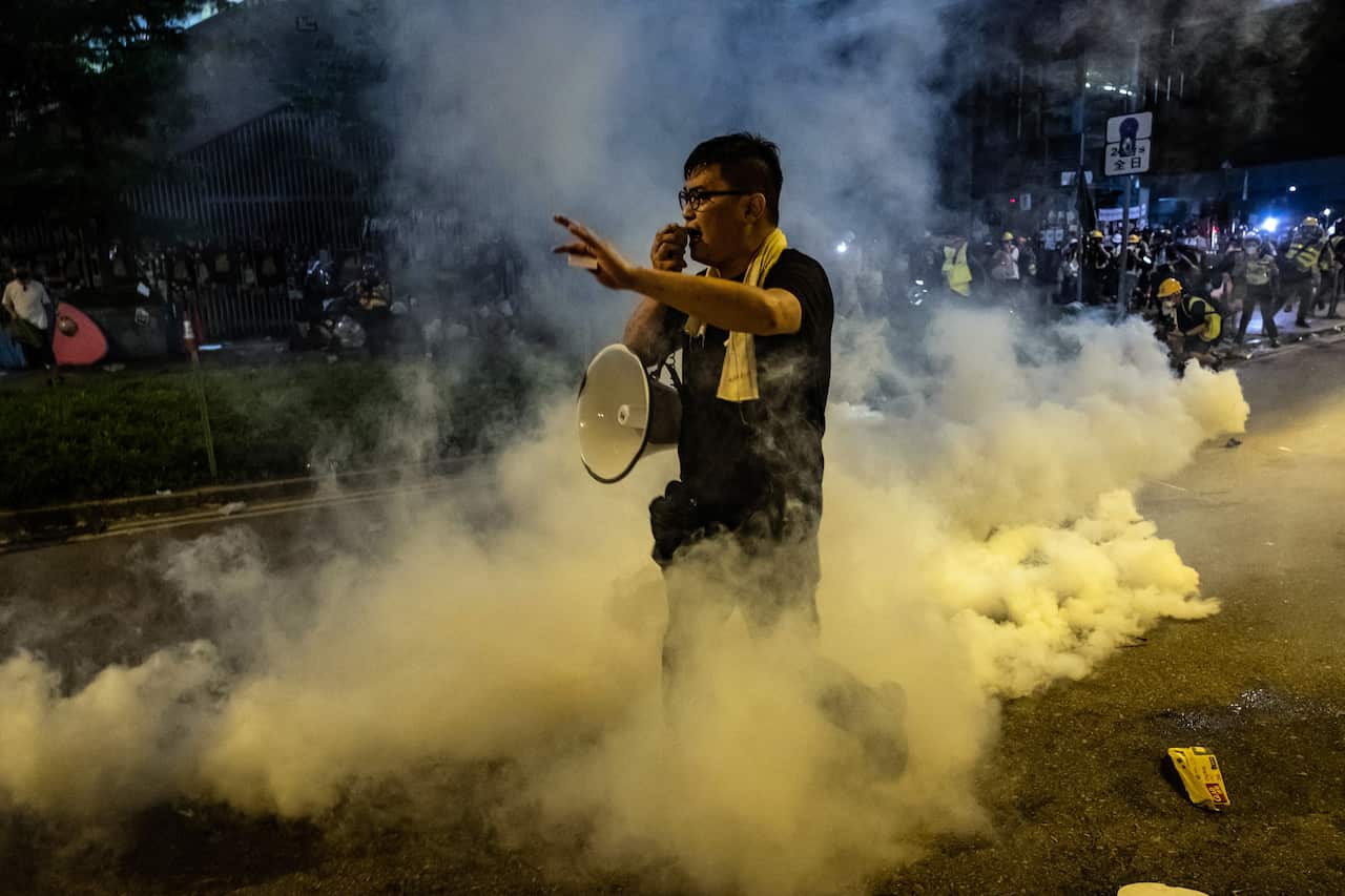 A protester stands in a cloud of teargas outside the Legislative Council in Hong Kong shortly after midnight on Tuesday morning, July 2, 2019. 