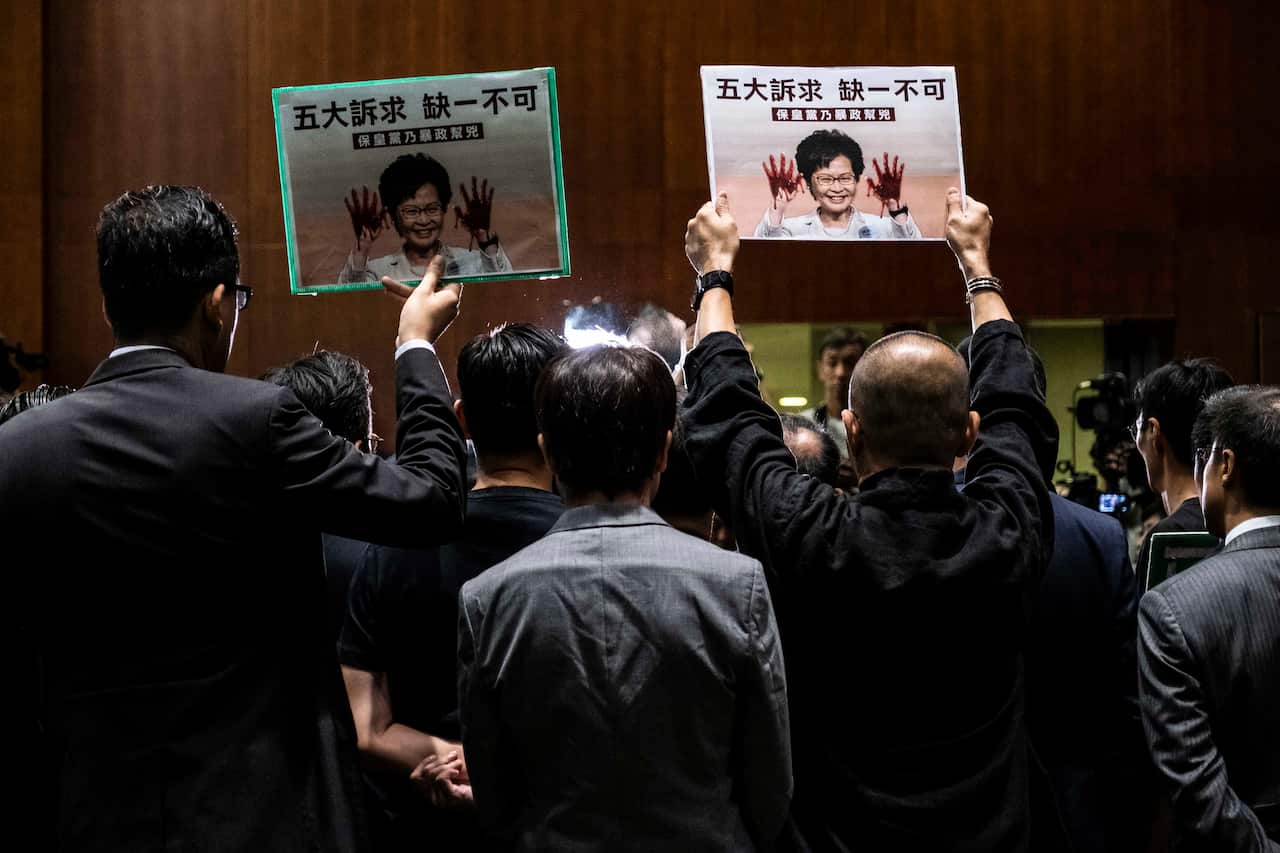 People hold signs depicting Hong Kong's Chief Executive Carrie Lam.
